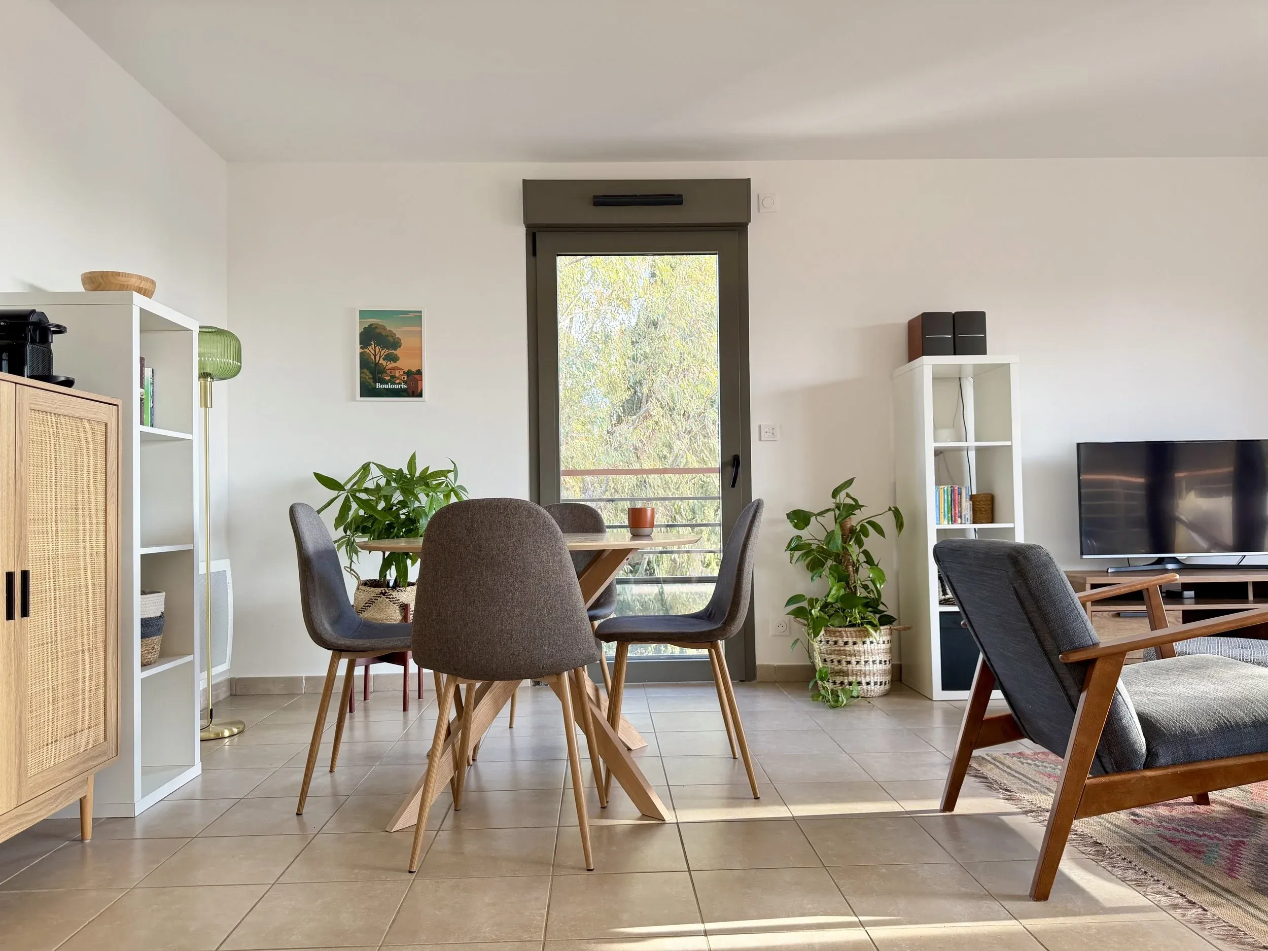 Espace repas avec table en bois et quatre chaises grises