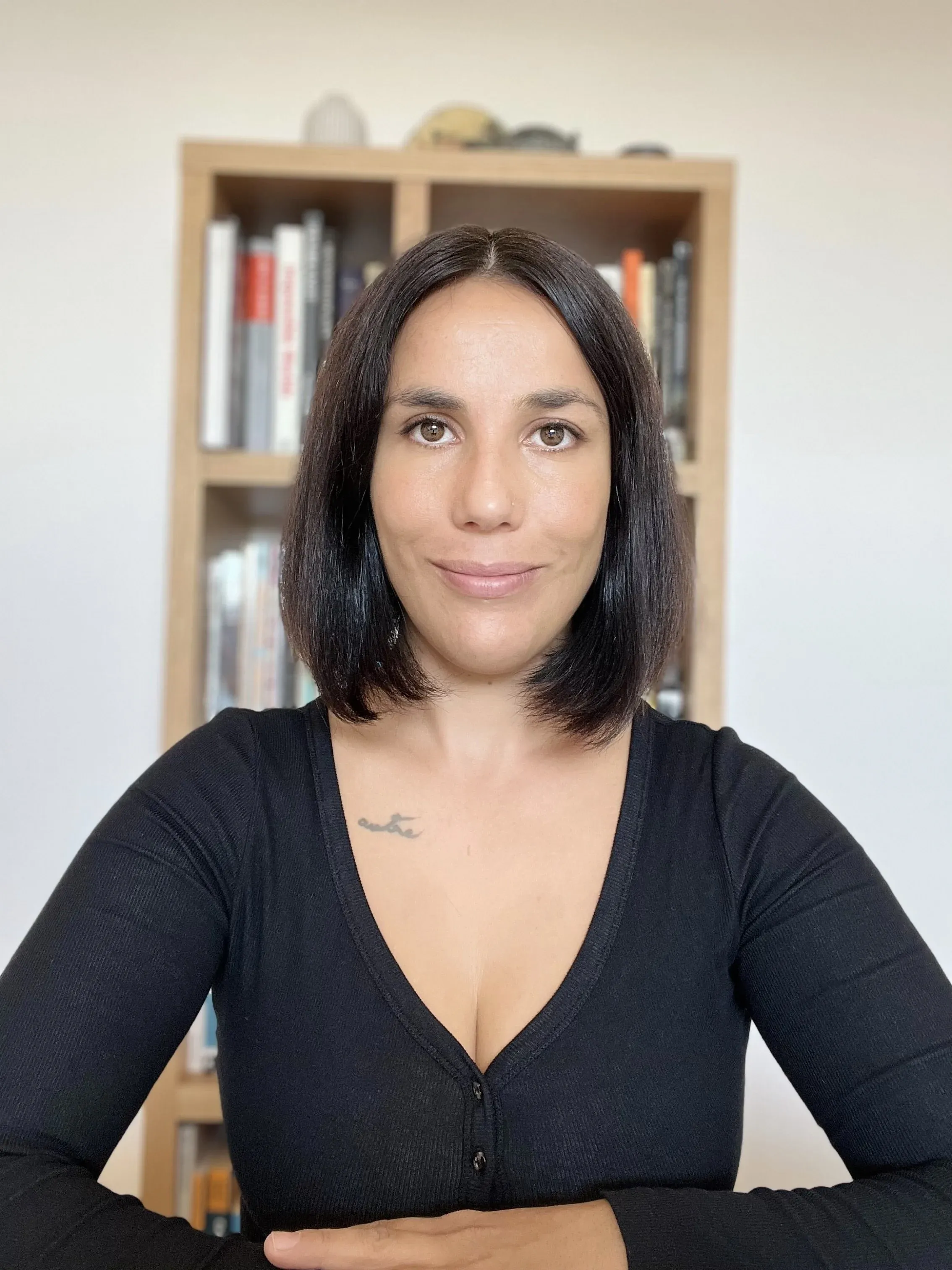 Méliké Elmas, designer d’intérieur, assise devant une bibliothèque