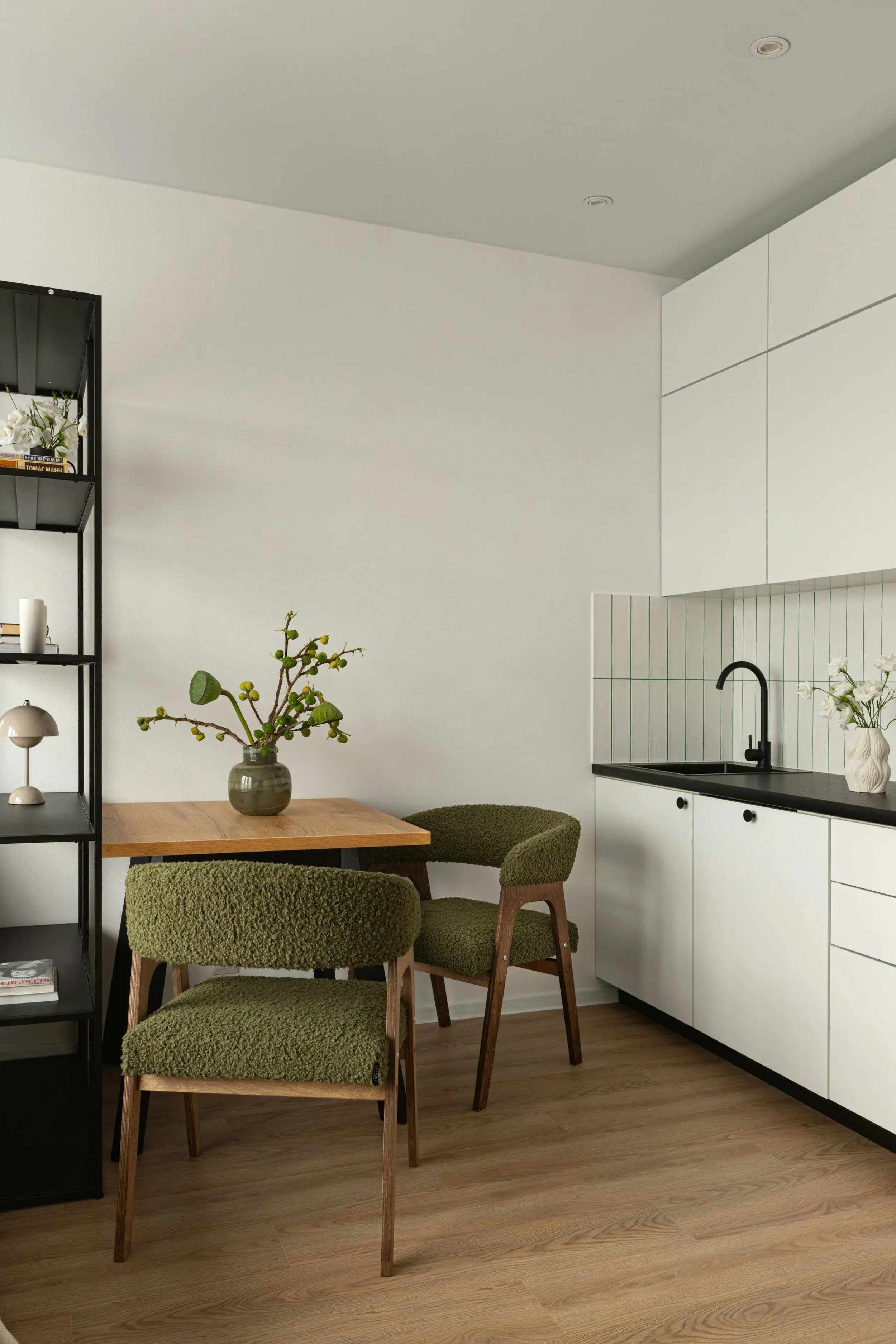Coin repas contemporain avec chaises vertes et cuisine blanche